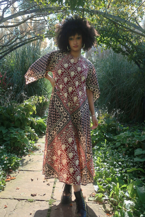 Model wears our Emmylou Patchwork Maxi Dress in Cherry Red & Black as a loose and floaty kaftan. A retro 70's Adini inspired look by All About Audrey