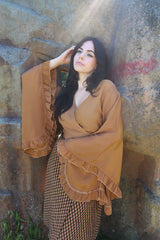 model image of our Venus Khroma wrap top in Golden Sands, a neutral, earthy, antique gold tone which is easy to style and versatile to wear! Inspired by 70's bohemia by All About Audrey