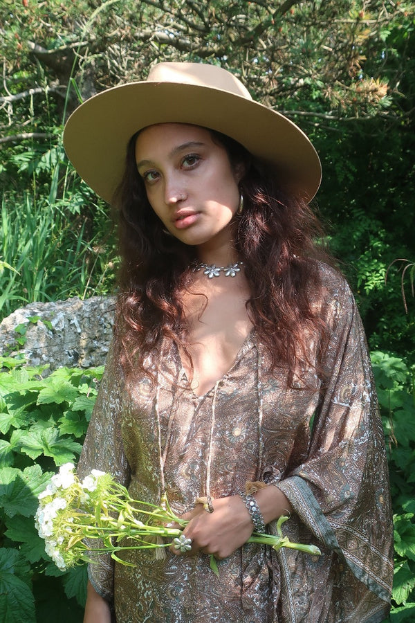Model wears our Sierra hat in Fawn. A light natural beige inspired by vintage 1970s prairie and western cowboy styles. Classic wide brim and high crown Fedora design with a decorative thin ribbon and simple brim by All About Audrey