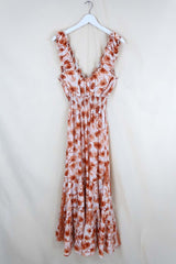 Flat lay of Maisie Maxi Dress in Candied Orange Watercolour Floral, a retro floaty frill dress inspired by the 70s bohemian fashion by All About Audrey