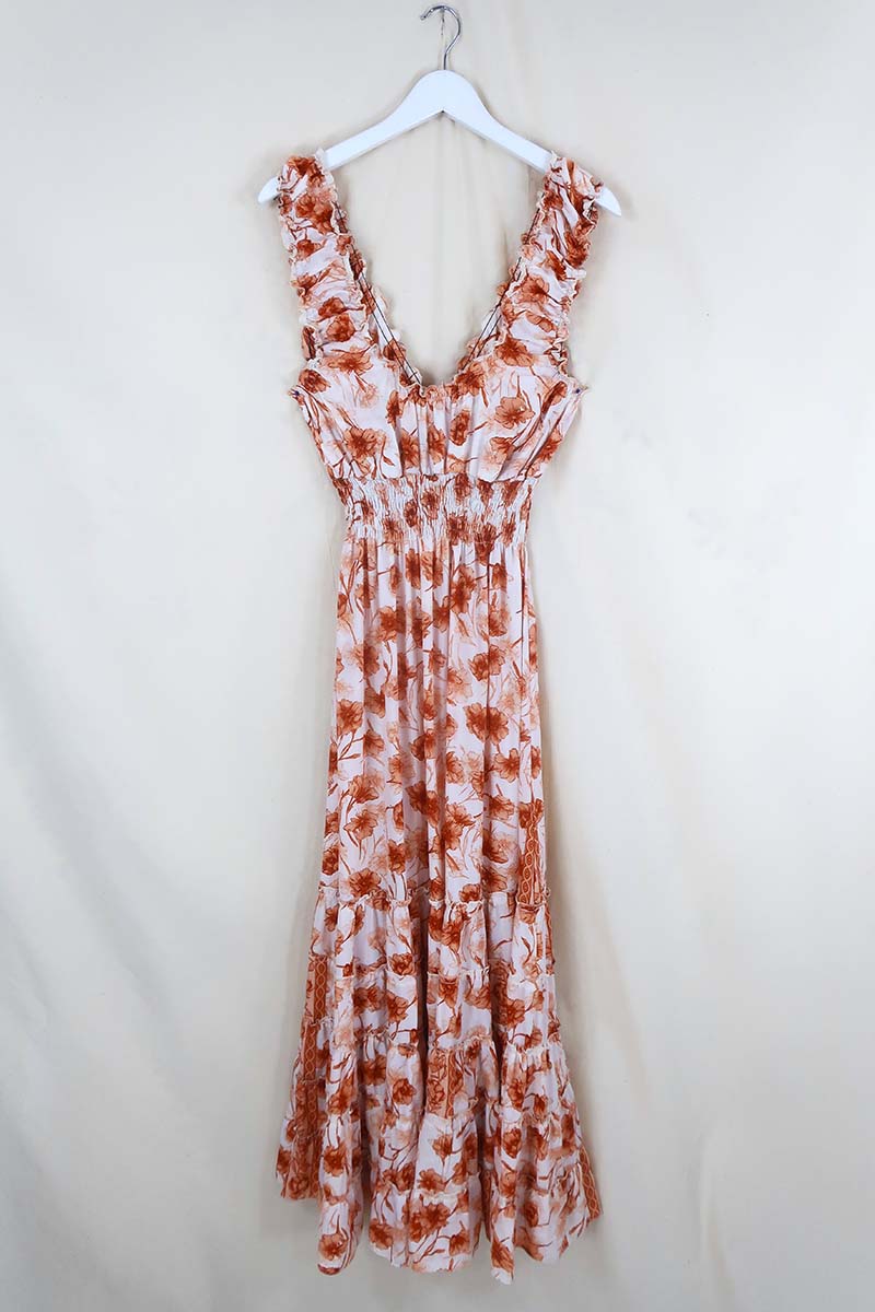 Flat lay of Maisie Maxi Dress in Candied Orange Watercolour Floral, a retro floaty frill dress inspired by the 70s bohemian fashion by All About Audrey