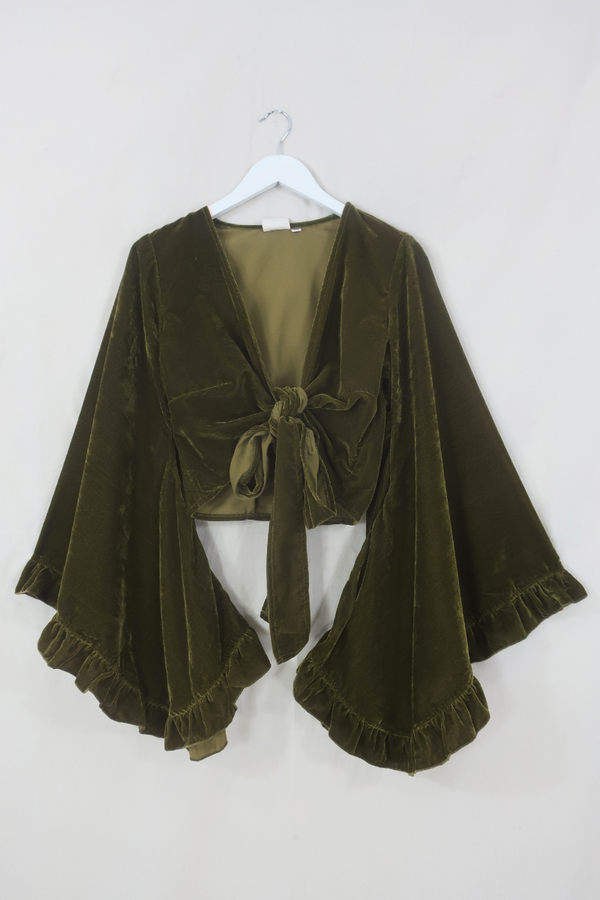 Flatlay of our Khroma Venus Wrap Top in Olive Green Velvet. 1970s style design with huge butterfly bell sleeves and luxurious retro velvet earthy tones by All About Audrey