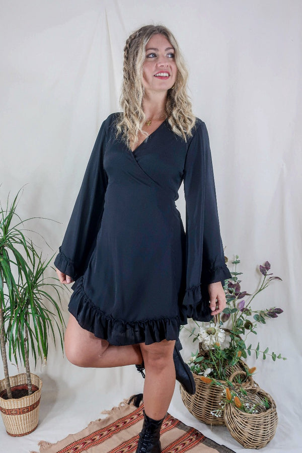 Model wears our Venus Khroma wrap dress in Vampy Black, a sleek and sultry classic which is easy to style and versatile to wear! Our model wears it here wrapped at the waist. Inspired by 70's bohemia by All About Audrey