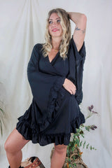Model wears our Venus Khroma wrap dress in Vampy Black, a sleek and sultry classic which is easy to style and versatile to wear! Our model wears it here wrapped at the waist. Inspired by 70's bohemia by All About Audrey