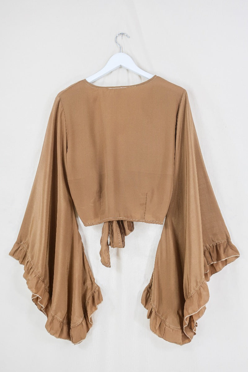 Flat lay off our Venus Khroma wrap top in Golden Sands, a neutral, earthy, antique gold tone which is easy to style and versatile to wear! Inspired by 70's bohemia by All About Audrey