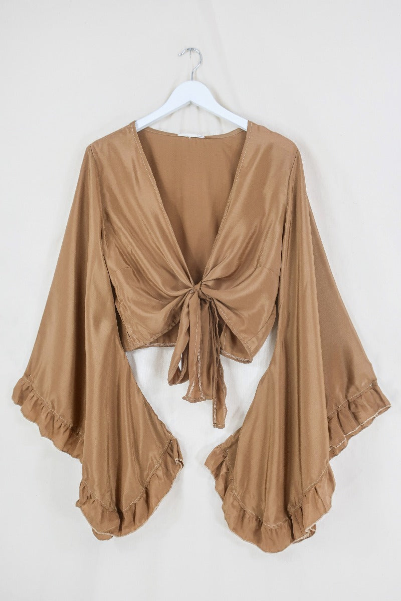 Flat lay off our Venus Khroma wrap top in Golden Sands, a neutral, earthy, antique gold tone which is easy to style and versatile to wear!  Inspired by 70's bohemia by All About Audrey