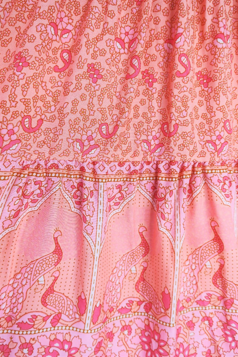 close up detail contrast indian style block printed hemline and tiered cut on peacock prairie bohemian maxi skirt in peachy rose pink rayon by all about audrey