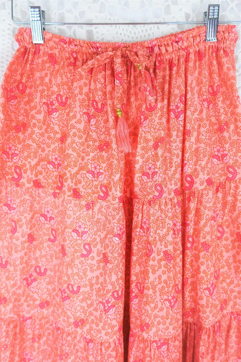 close up drawstring waist and print detail peacock prairie bohemian tiered maxi skirt in peachy rose pink indian printed rayon by all about audrey