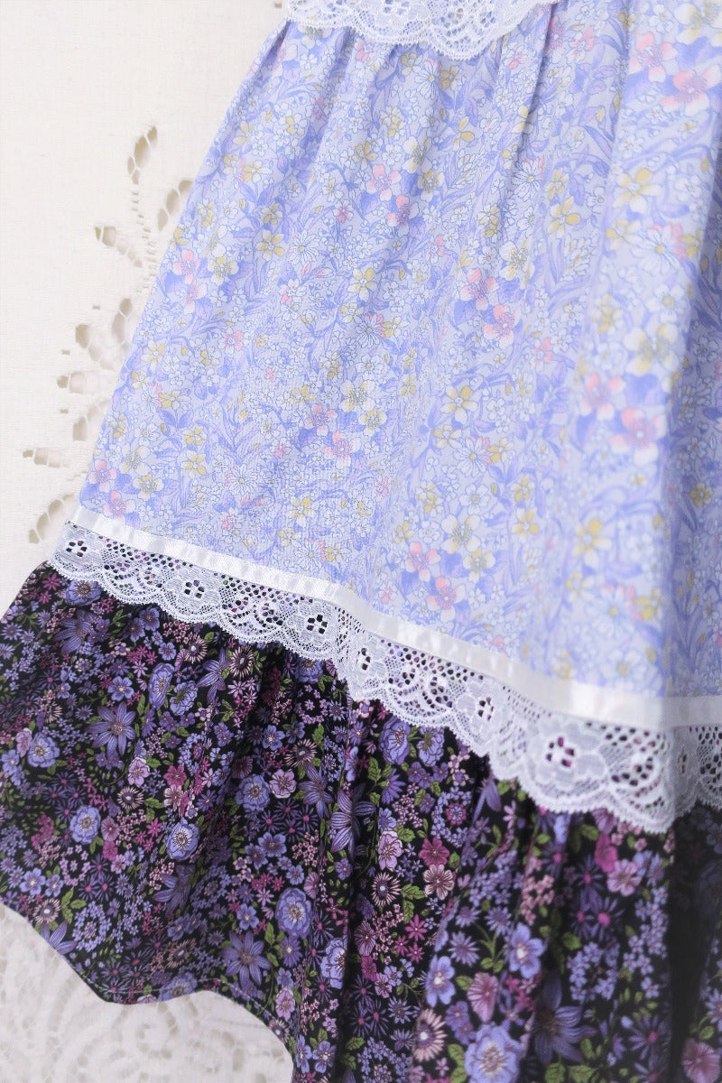  Extreme close up of the two main cotton fabrics which are a combination of two ditsy boho floral wildflower tonal lilac prints separated by prairie antique style lace By All About Audrey