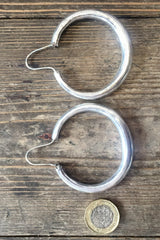 laid flat next to coin to show size large silver painted hoop earrings from our boho jewellery collection at all about audrey