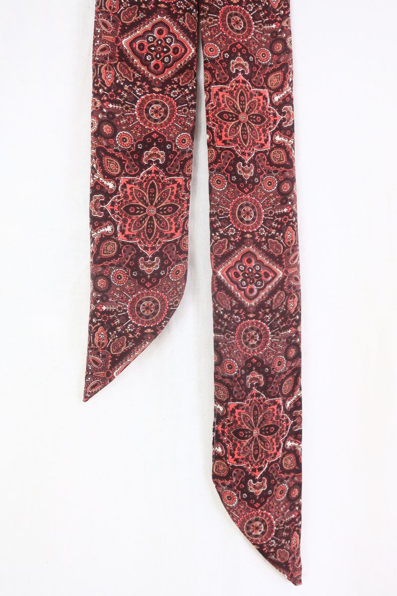 flat lay of 70s style skinny necktie in bowie red mandala print burgundy cherry ribbon scarf hairtie boho accessory by all about audrey