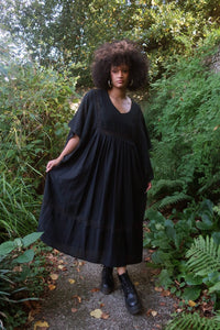 Model wears our Cordelia Midi Dress in Nightshade Black as an oversized loose smock style fit. She shows off the full skirt, tapered sleeves and crochet detailing inspired by 1970s folk designs. By All About Audrey 