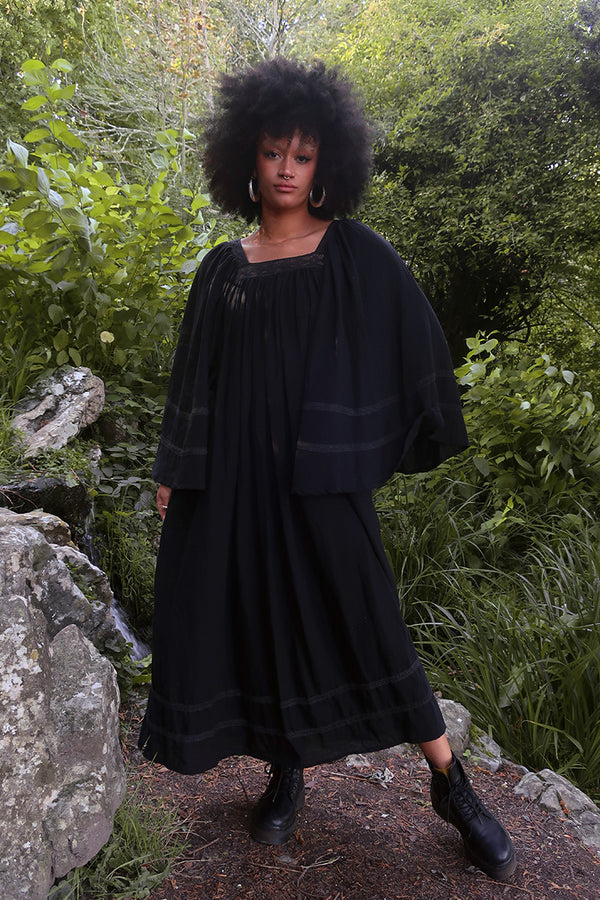Model wears our Raven Maxi Dress in Nightshade Black. A loose smock style with folky crochet neckline and sleeves. Wear loose or belted for a more fitted look. By All About Audrey