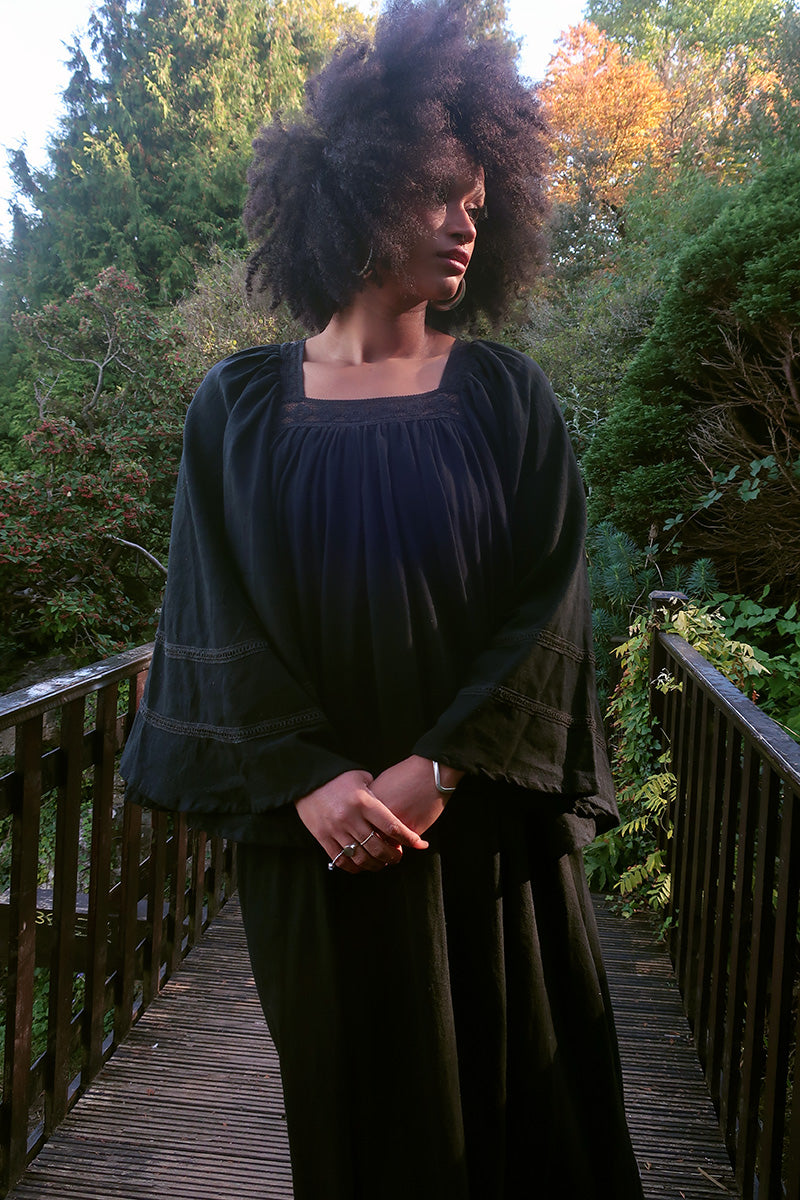 Model wears our Raven Maxi Dress in Nightshade Black. A loose smock style with folky crochet neckline and sleeves. Wear loose or belted for a more fitted look. By All About Audrey