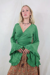 Model wears our Venus Khroma Top in Grass Green worn in a wrap around style and long floaty butterfly frill sleeves by All About Audrey