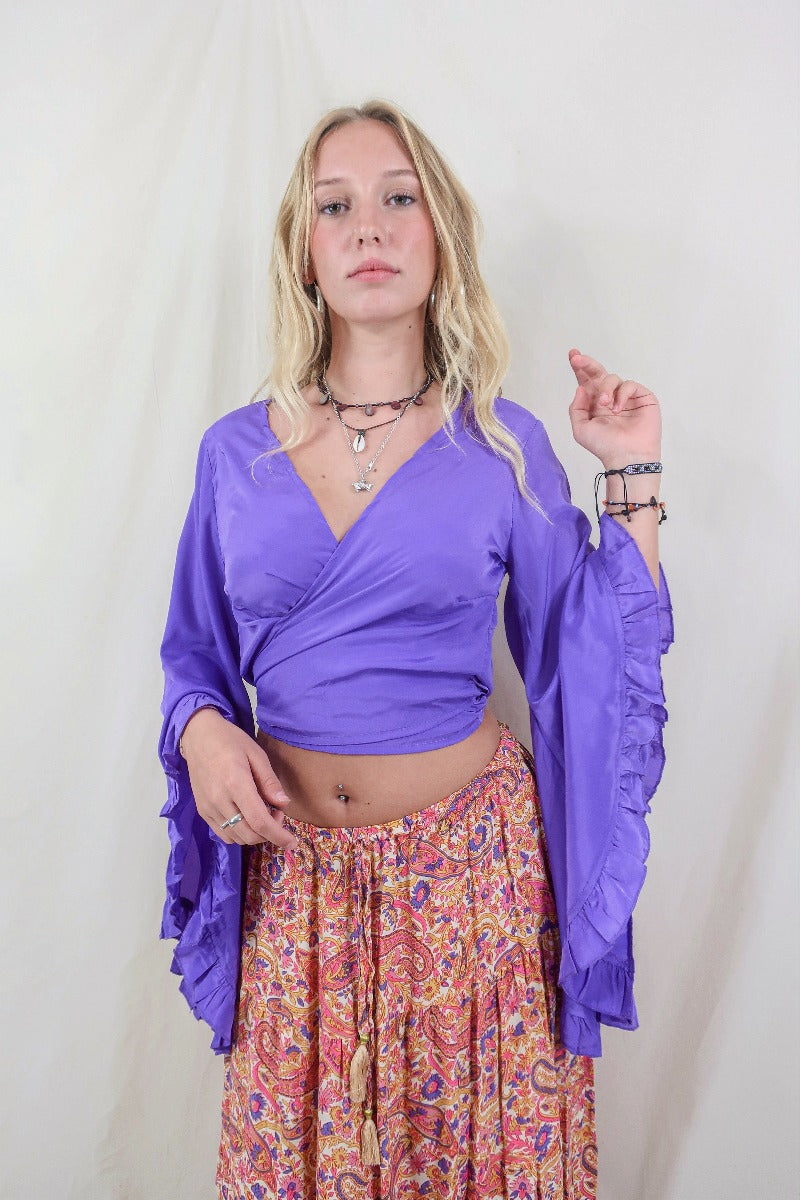 Model wearing electric violet Khroma Venus Top worn in a wrap style. Made from viscose fabric they're silky and soft have an elegant shape all by all about audrey