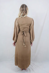 Model wears our retro style Khroma Lola Maxi dress in Gold Sands. Worn here in a wraparound style, the model shows off the back and the adjustable waist that gives the wearer an elegant shape. By All About Audrey