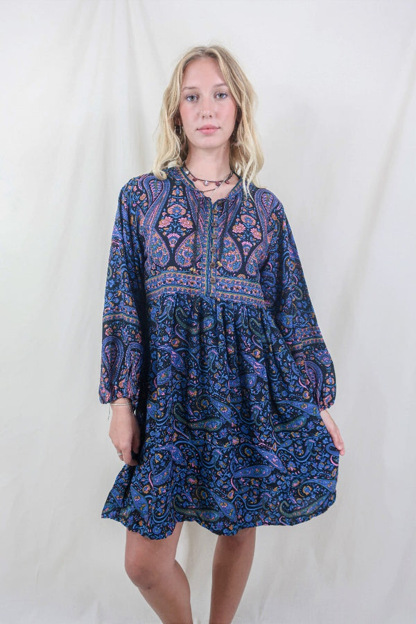 Model wears our Florence Mini Dress in Midnight Sapphire, a beautiful paisley print with balloon sleeve and above the knee cut. Inspired by the bohemian 70s style. By All About Audrey 