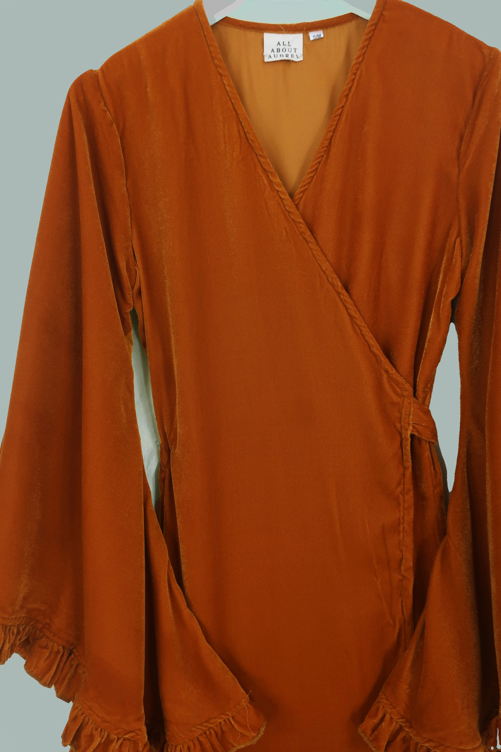 Close up of our Khroma Venus Maxi Dress in Marmalade Yellow Velvet. Showing the dress wrapped around and tied at the back. A flattering vintage silhouette reminiscent of 1970s style by All About Audrey