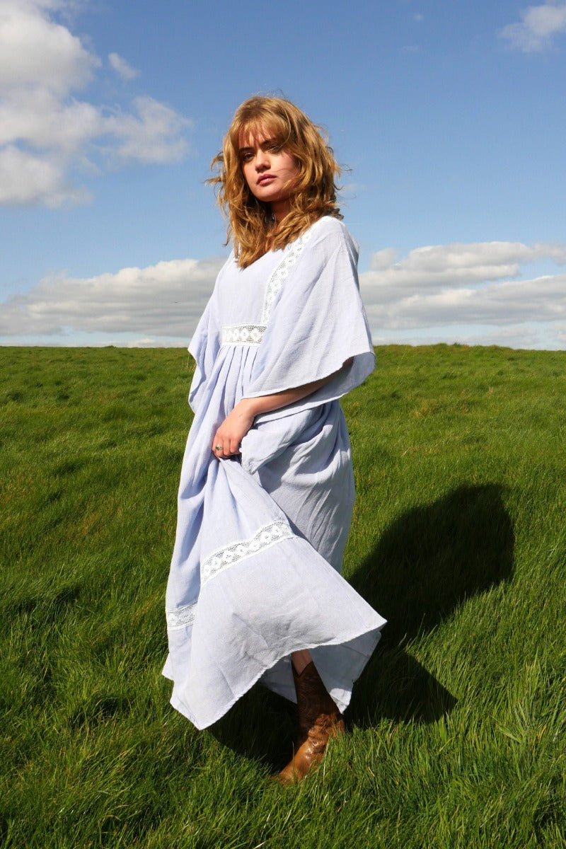 Model wears our Cordelia Midi Dress in Cornflower Blue. A floaty bohemian and folky style smock dress with crochet detailing on the bust panel and skirt by All About Audrey