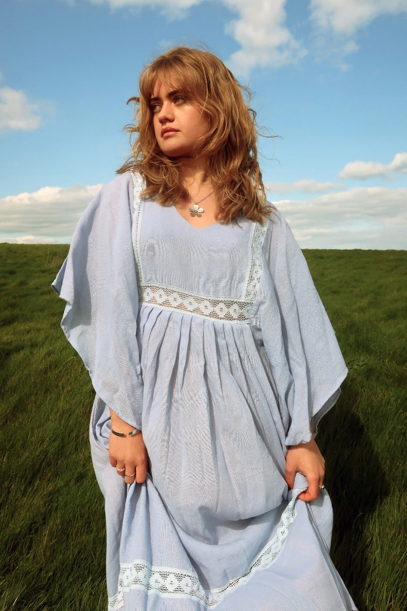 Model wears our Cordelia Midi Dress in Cornflower Blue. A floaty bohemian and folky style smock dress with crochet detailing on the bust panel and skirt by All About Audrey