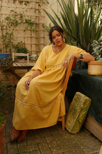 Model wears our Cordelia Midi Dress in Daffodil Yellow. A beautiful folky and bohemian style with it's crochet bust panel and skirt. Such a lovely sun kissed yellow tone by All About Audrey