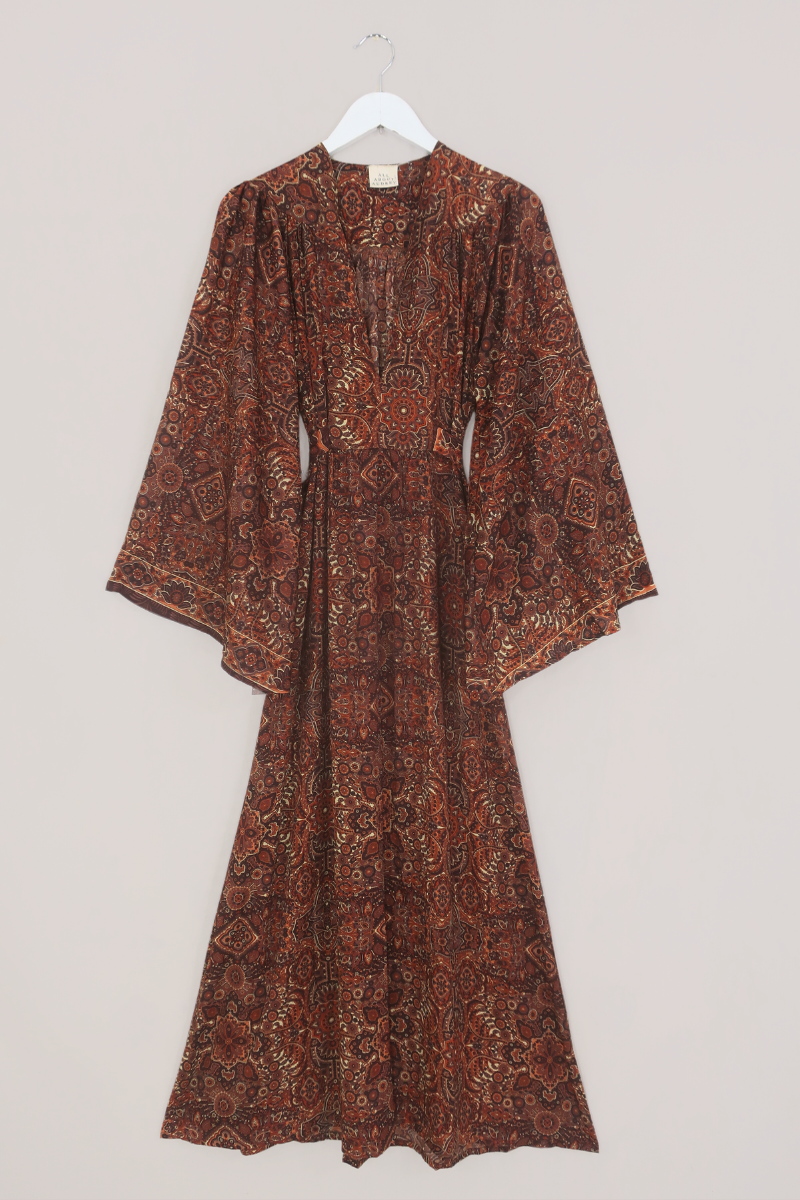 Flat-lay of our Stevie Mandala Kaftan Dress in Dylan Brown. An earthy psychedelic pattern of warm retro brown and orange by All About Audrey
