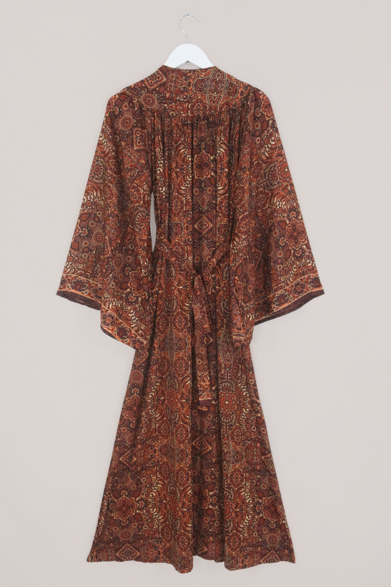 Flat-lay of our Stevie Mandala Kaftan Dress in Dylan Brown. An earthy psychedelic pattern of warm retro brown and orange by All About Audrey