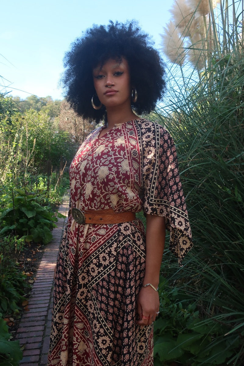 Model wears our Emmylou Patchwork Maxi Dress in Cherry Red & Black. Worn belted at the waist to give a more fitted shape. A retro 70's Adini inspired look by All About Audrey