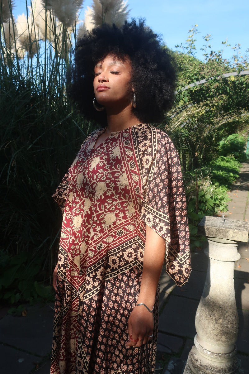 Model wears our Emmylou Patchwork Maxi Dress in Cherry Red & Black as a loose and floaty kaftan. A retro 70's Adini inspired look by All About Audrey