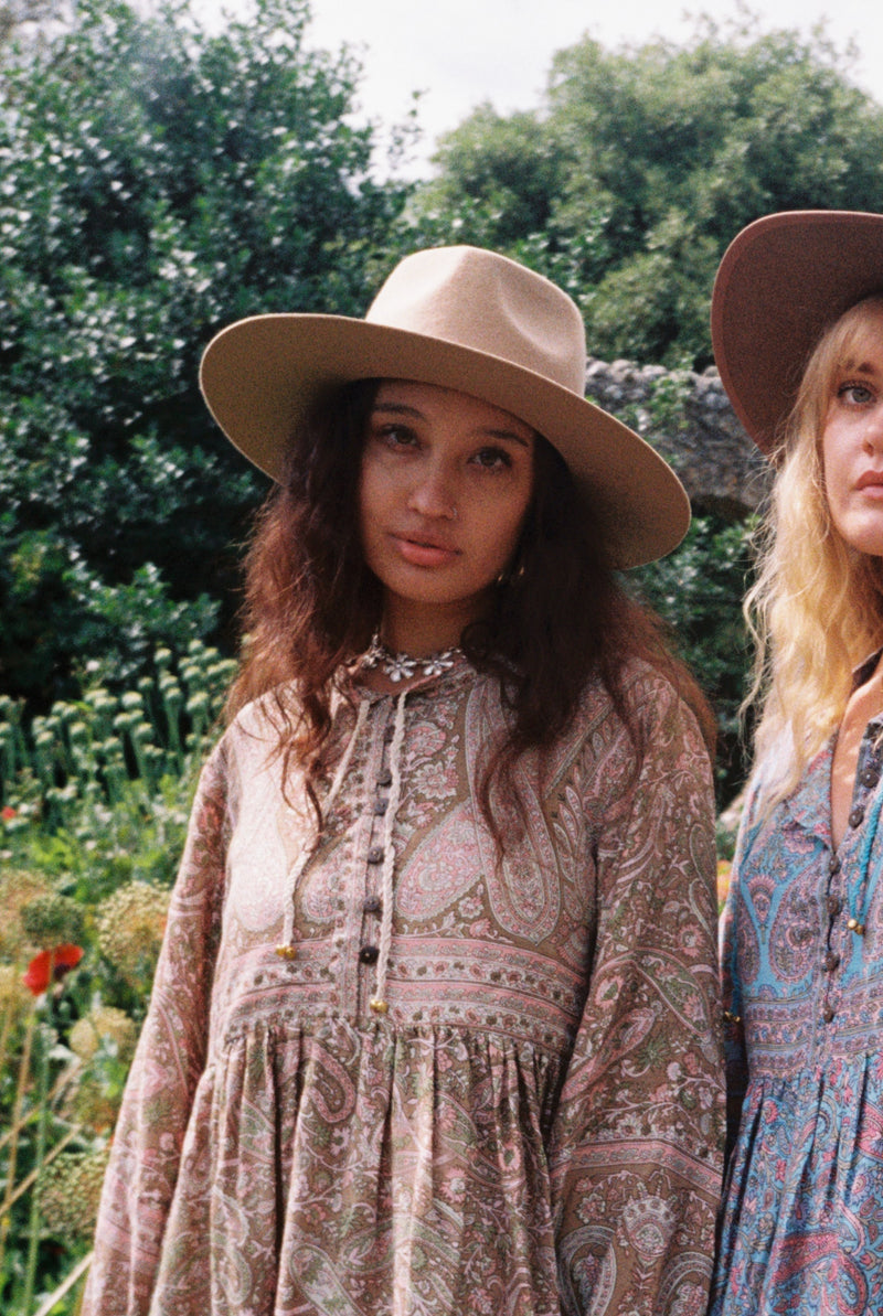 Model wears our Sierra hat in Fawn. A light natural beige inspired by vintage 1970s prairie and western cowboy styles. Classic wide brim and high crown Fedora design with a decorative thin ribbon and simple brim by All About Audrey