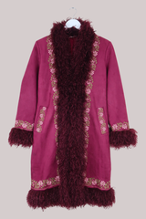 Burgundy red coat with fur trim on a beige background