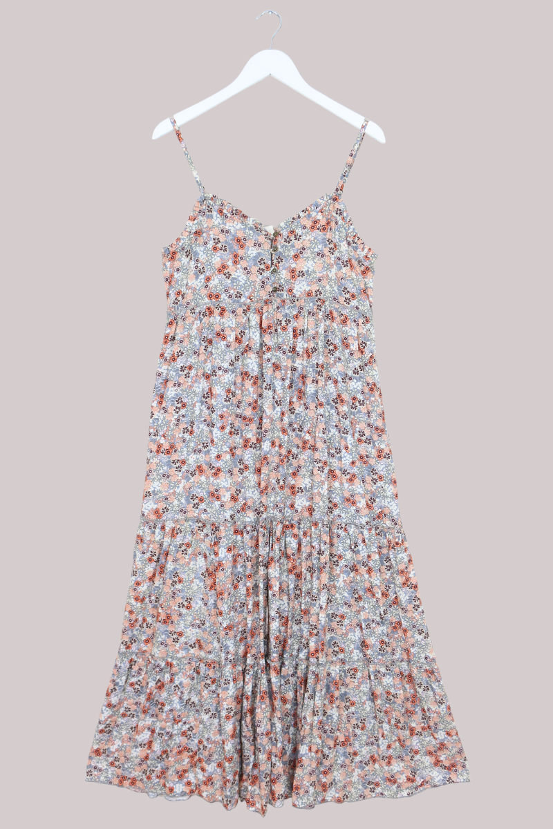 Floral dress on a hanger against a neutral background