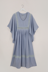 Flat lay of our Cordelia Midi Dress in Cornflower Blue. A folky vintage smock style silhouette with a crochet square bust panel and huge elegant wide sleeves by All About Audrey