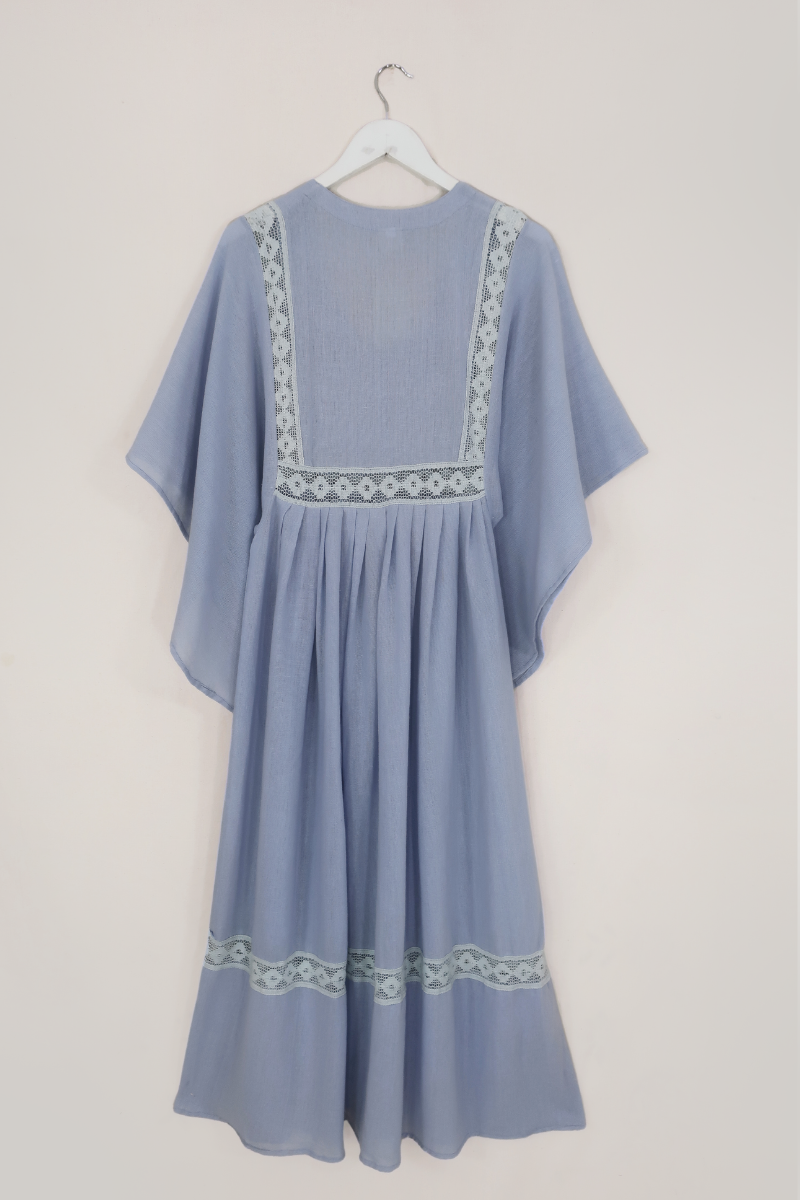 Flat lay of our Cordelia Midi Dress in Cornflower Blue. A folky vintage smock style silhouette with a crochet square bust panel and huge elegant wide sleeves by All About Audrey