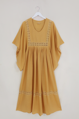 Flat lay of our Cordelia Midi Dress in Daffodil Yellow. A folky vintage smock style silhouette with a crochet square bust panel and huge elegant wide sleeves by All About Audrey