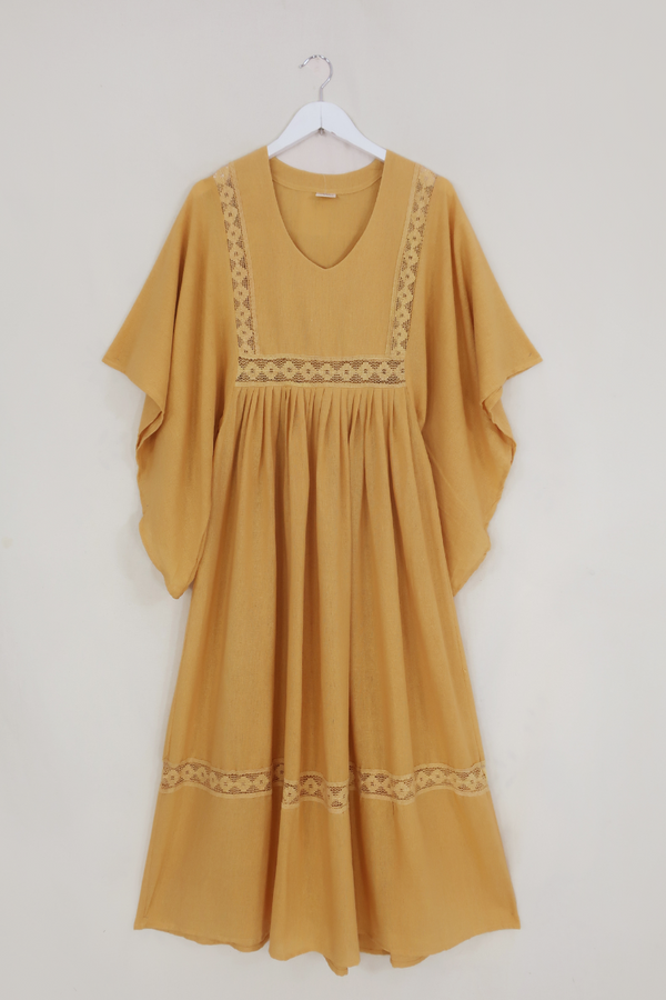 Flat lay of our Cordelia Midi Dress in Daffodil Yellow. A folky vintage smock style silhouette with a crochet square bust panel and huge elegant wide sleeves by All About Audrey