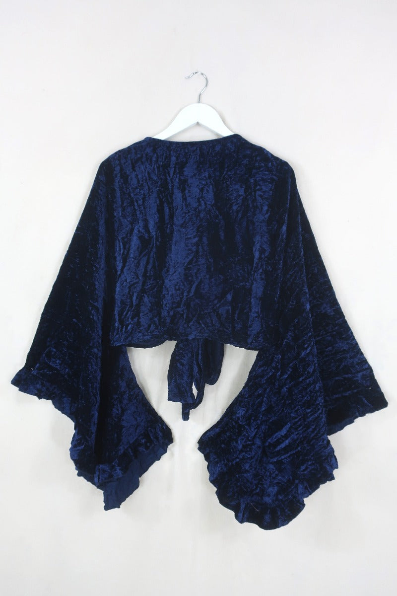 Flatlay of our Khroma Venus Wrap Top in Galaxy Blue Velvet. 1970s style design with huge butterfly bell sleeves and luxurious retro velvet earthy tones by All About Audrey