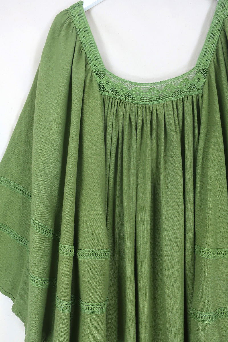 Flat lay of our Raven Maxi Dress in Pixie Green. A loose smock style with folky crochet neckline and sleeves By All About Audrey