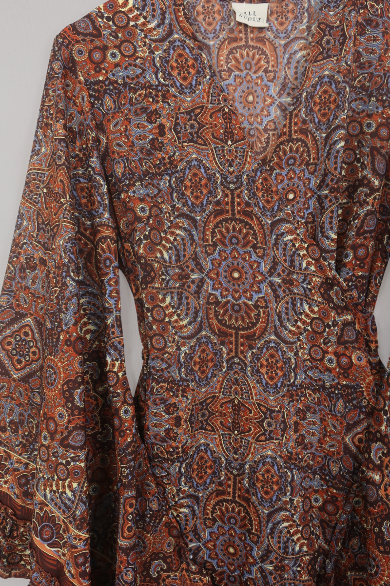 Flat-lay of our Venus Mini Wrap Dress in Jagger Lilac & Rust Mandala. A mix of deep umber brown and a contrasting folky blue, all in a kaleidoscope of patterns by All About Audrey