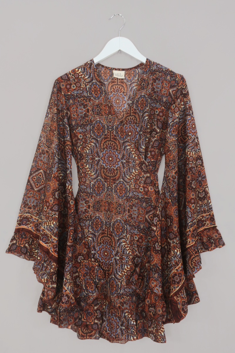 Flat-lay of our Venus Mini Wrap Dress in Jagger Lilac & Rust Mandala. A mix of deep umber brown and a contrasting folky blue, all in a kaleidoscope of patterns by All About Audrey