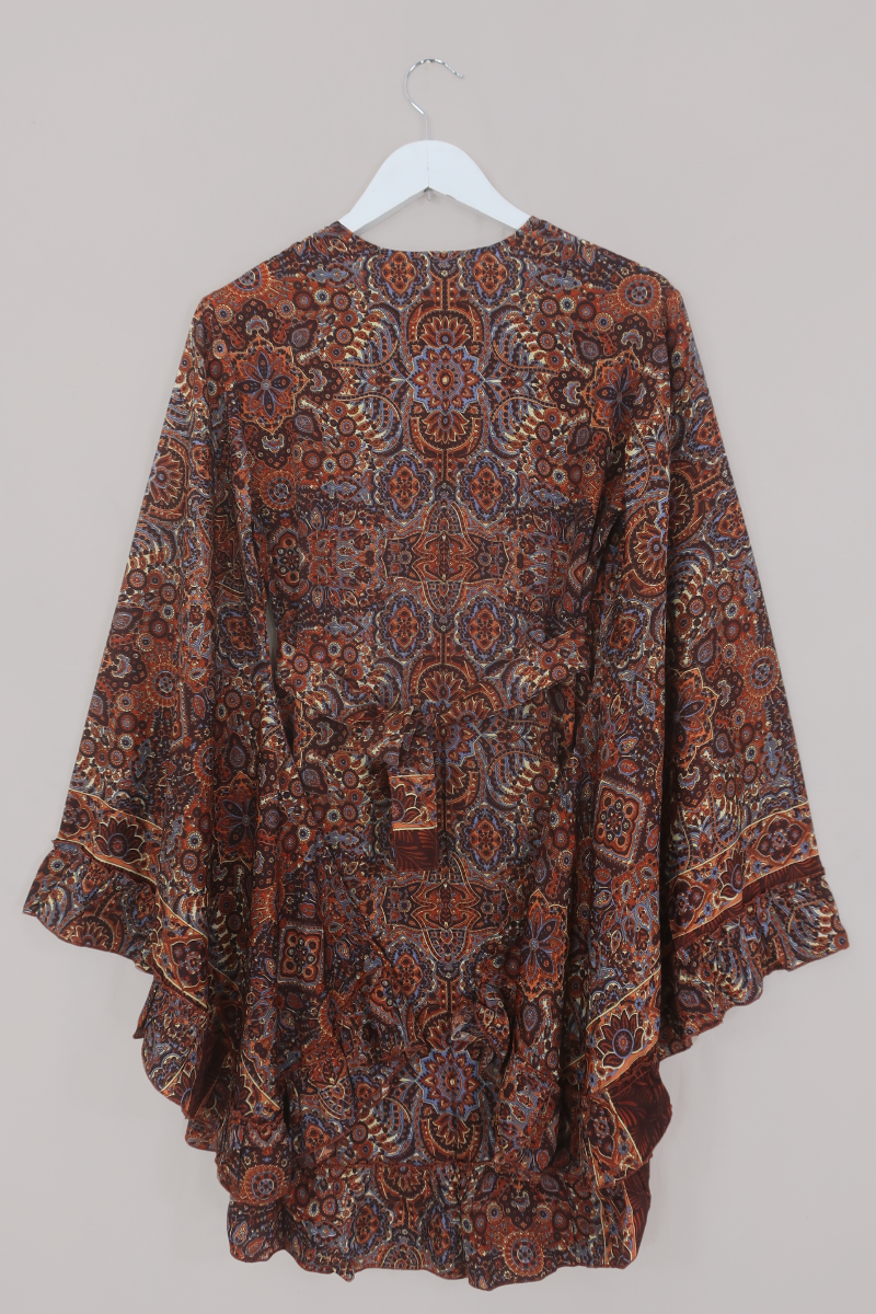 Flat-lay of our Venus Mini Wrap Dress in Jagger Lilac & Rust Mandala. A mix of deep umber brown and a contrasting folky blue, all in a kaleidoscope of patterns by All About Audrey