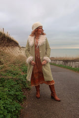 Audrey wears our Janis Long Coat in Agate Green Corduroy. Worn open over a Peacock Primrose Dress in Tan and Tumeric. A beauitful,  retro 1970's colour-way and design by All About Audrey. 