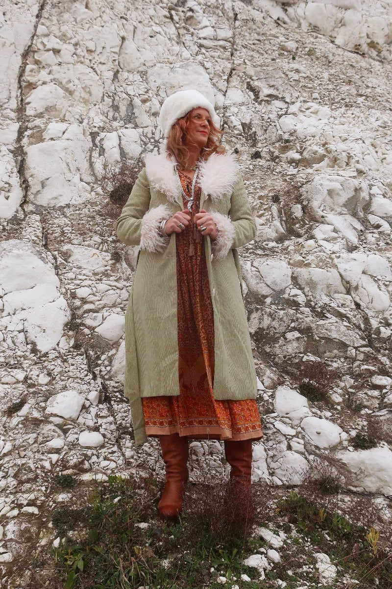 Audrey wears our Janis Long Coat in Agate Green Corduroy. Worn open over a Peacock Primrose Dress in Tan and Tumeric. A beauitful, retro 1970's colour-way and design by All About Audrey.