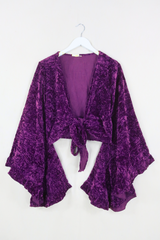 Flatlay of our Khroma Venus Wrap Top in Purple Quartz Velvet. 1970s style design with huge butterfly bell sleeves and luxurious retro velvet earthy tones by All About Audrey