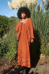 Model wears our Raven Maxi Dress in Red Clay. A loose smock style with folky crochet neckline and sleeves. Wear loose or belted for a more fitted look. By All About Audrey