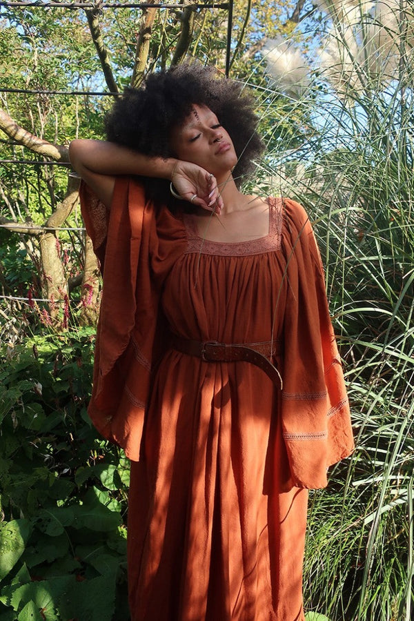 Model wears our Raven Maxi Dress in Red Clay. A loose smock style with folky crochet neckline and sleeves. Wear loose or belted for a more fitted look. By All About Audrey