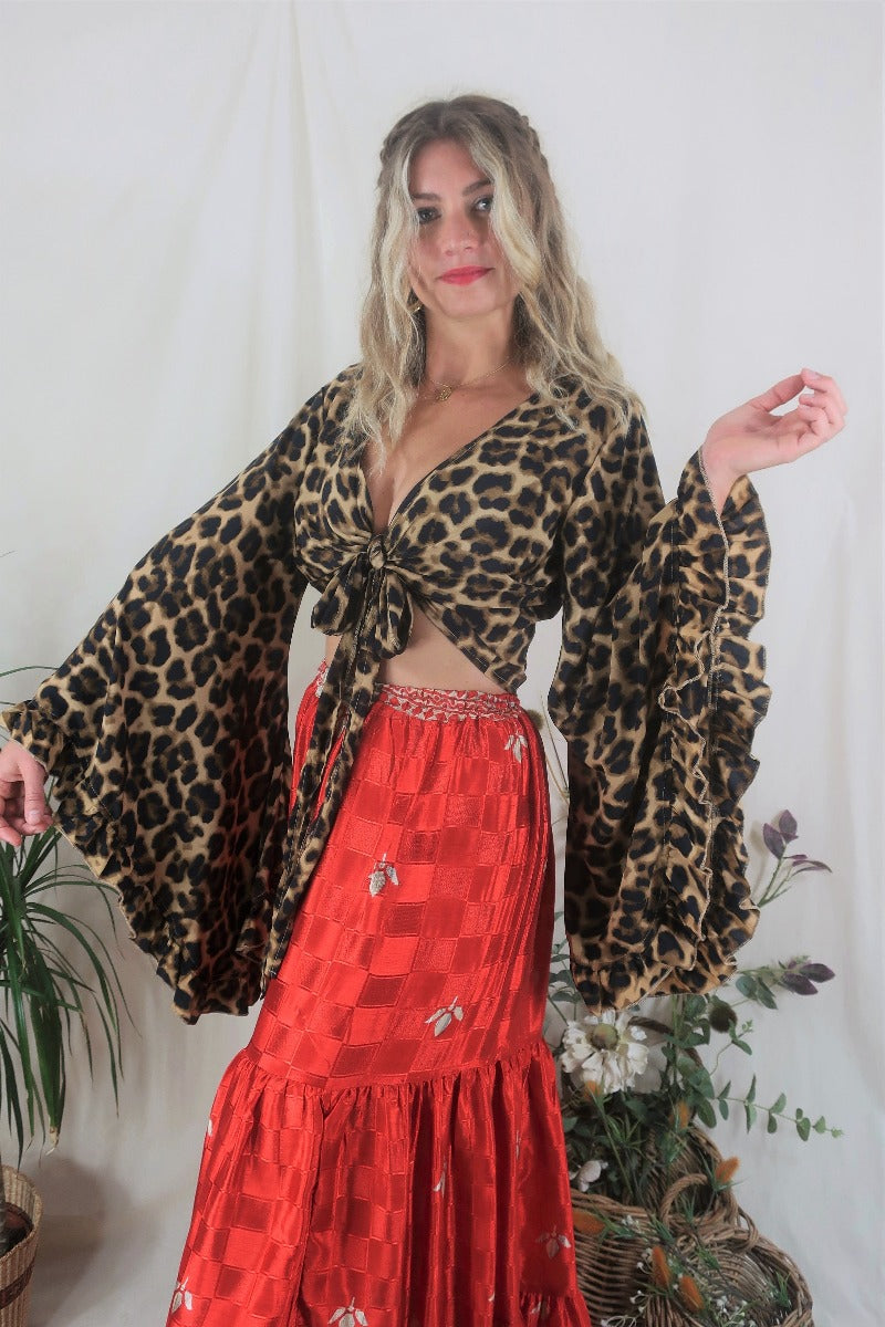 Model wears our Savannah Leopard Print Venus wrap top. Featuring an animal print in gold, brown and black tones by All About Audrey