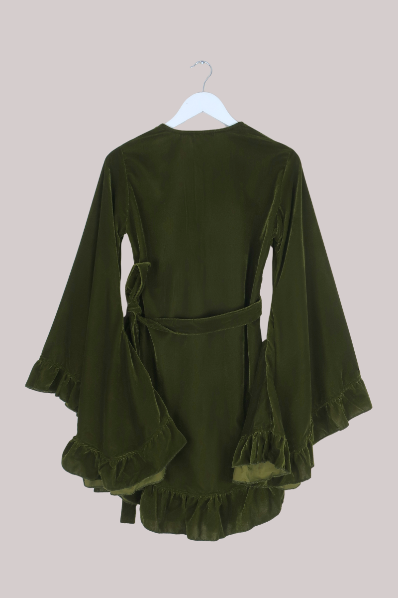 Green dress with ruffled details on a beige background