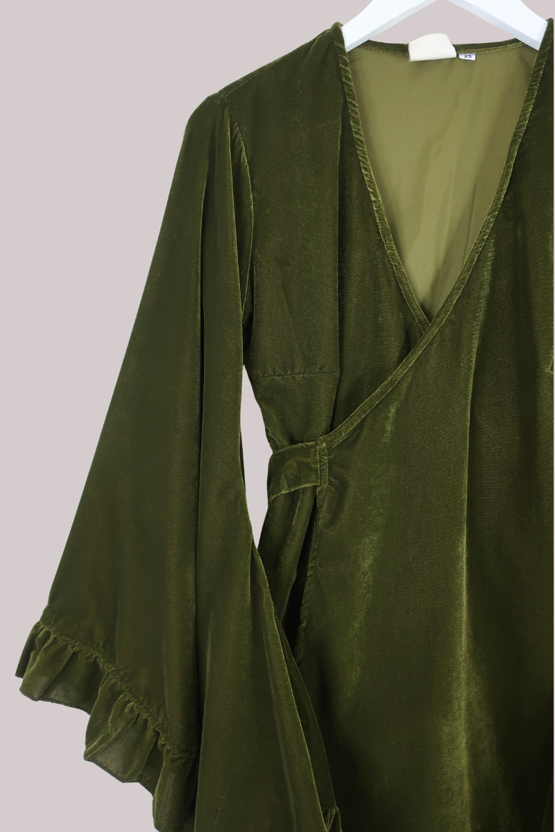Green robe on a hanger against a light background